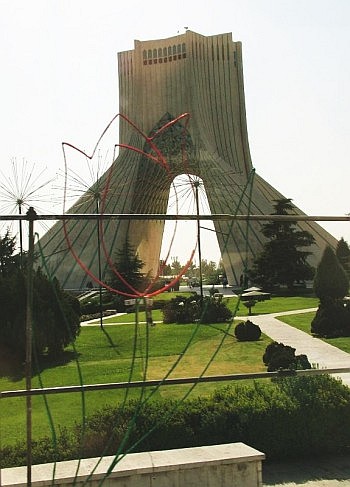 La tenda di cemento del monumento Azadi (‘libertà’) accoglie i visitatori all’esterno dell’aeroporto di Tehran; in primo piano un’insegna luminosa a forma di tulipano, simbolo del martirio [foto di Nicola Lecchi]